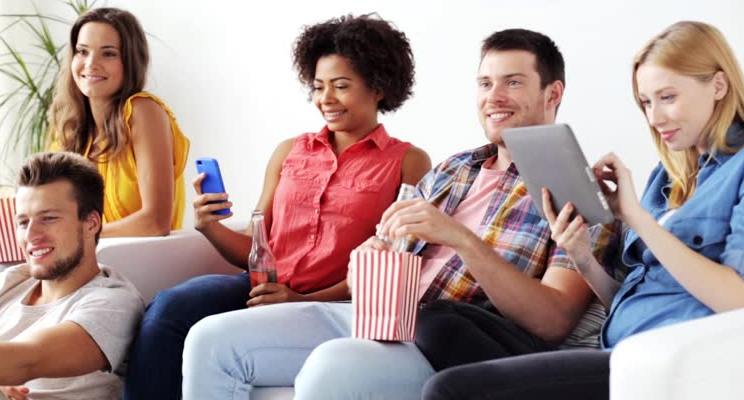 Group of friends sitting on a couch watching television