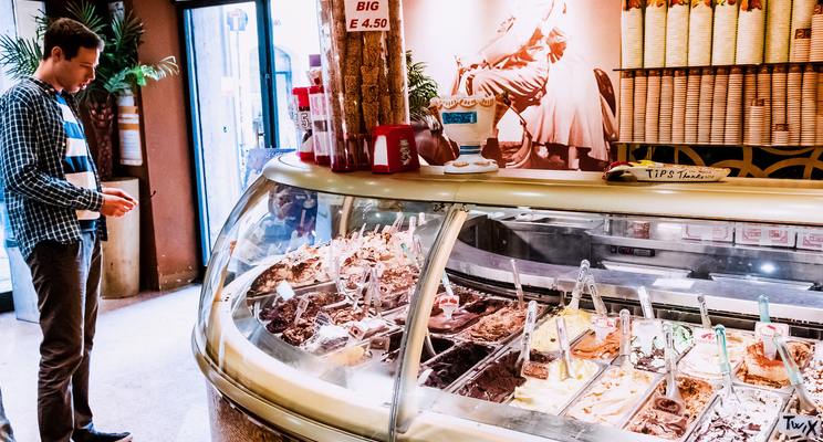Man looks at the various options for ice cream flavors at an ice cream parlour
