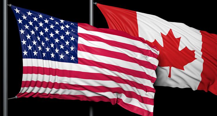 American and Canadian flags fly on flagpoles side-by-side