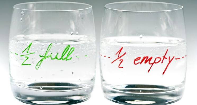 Two glasses with the same water level on marked half full and the other half empty