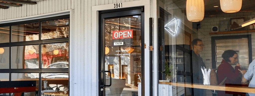 a storefront with window door and open sign
