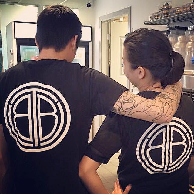 Karl Tang, Owner of The Bubble Tea Shop with his back turned so that the company logo on the back of his shirt is showing