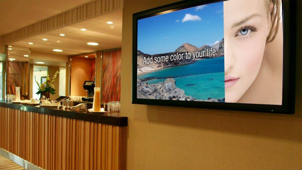 Digital signage TV display beside the front desk of a hotel with a promotional design for the hotel spa